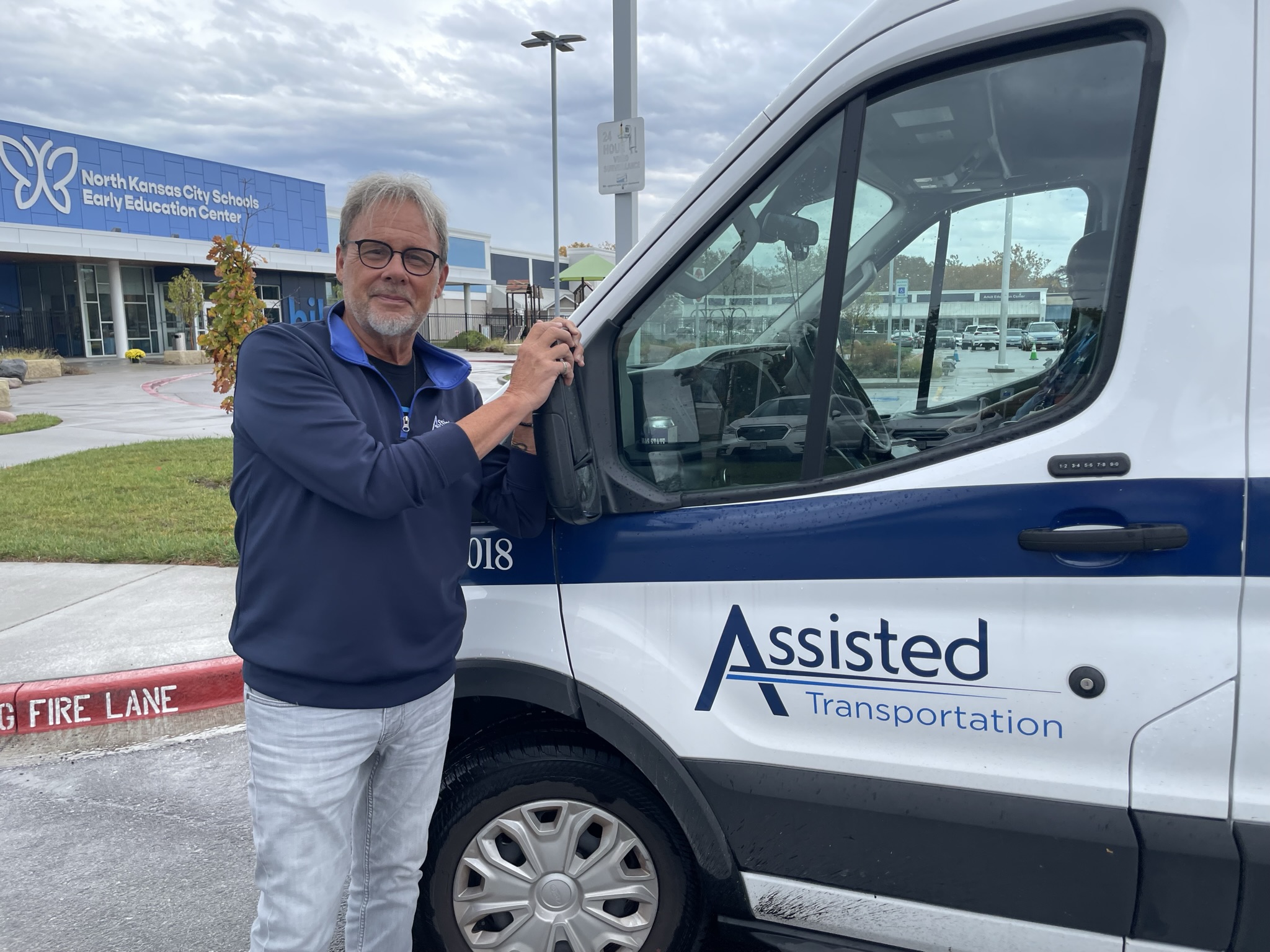 Assisted Uniformed Driver standing next to a van