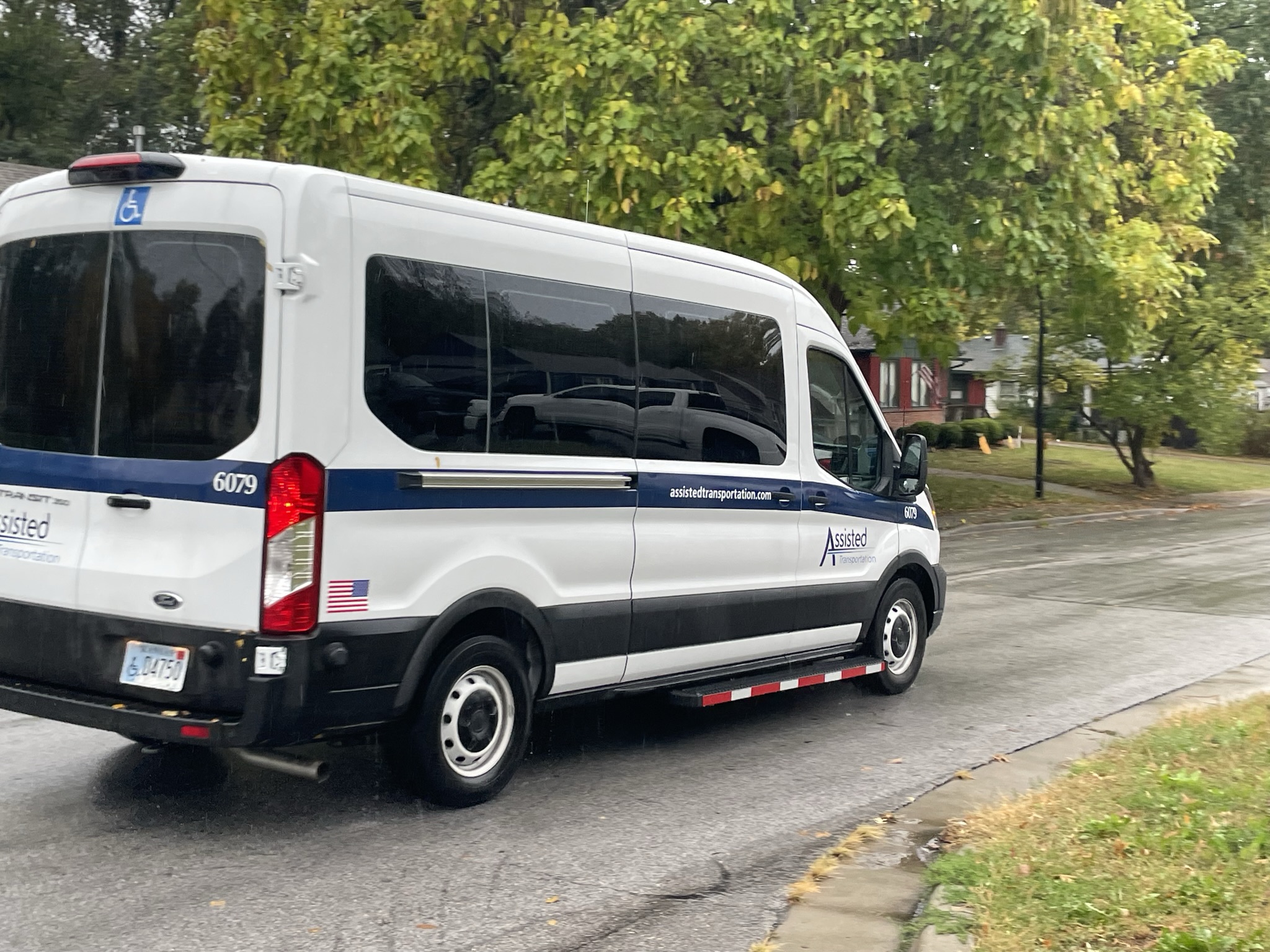 An Assisted Van travels down a residential street